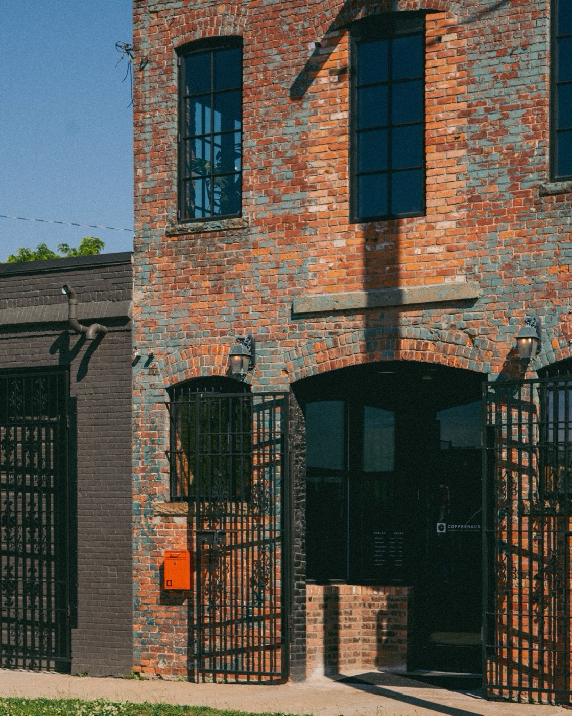 The Coffeehaus storefront in Detroit, brick facade with the orange mailbox and gated entry to the public hours