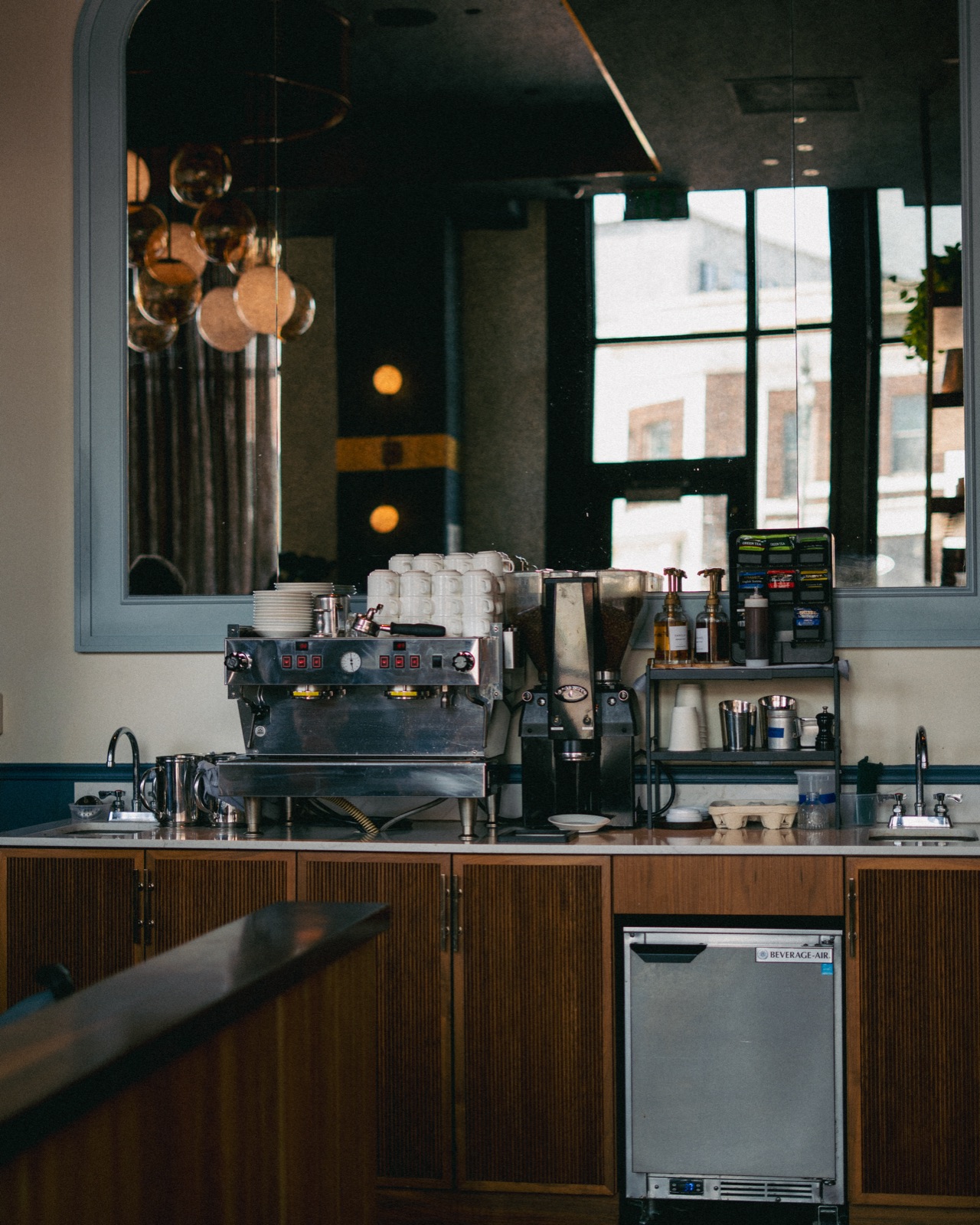Full espresso setup in the Godfrey lobby: La Marzocco, grinder, and cup stack